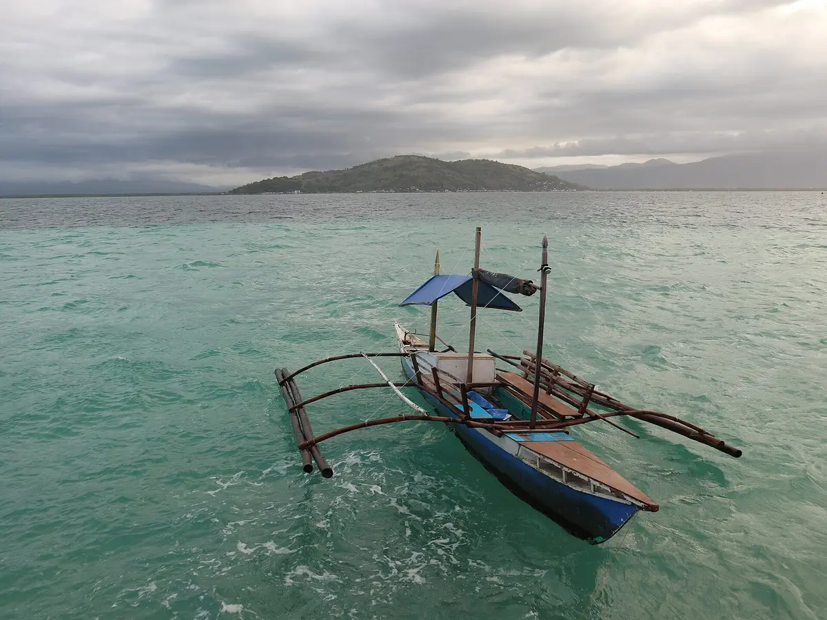 An outrigger boat near cottages at Manjuyod Sandbar