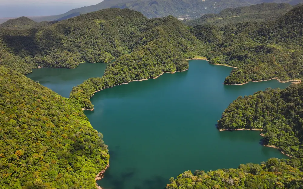 Lake Balanan surrounded by forested hills in Siaton, Negros Oriental