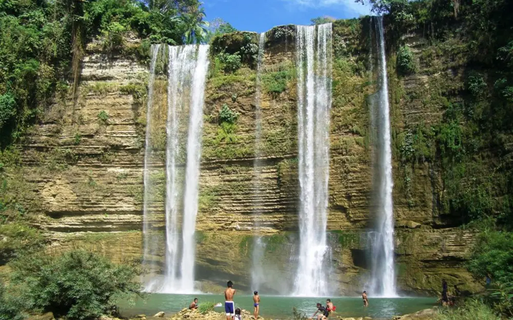 Wide curtain of water falling over the rock face at Niludhan Falls